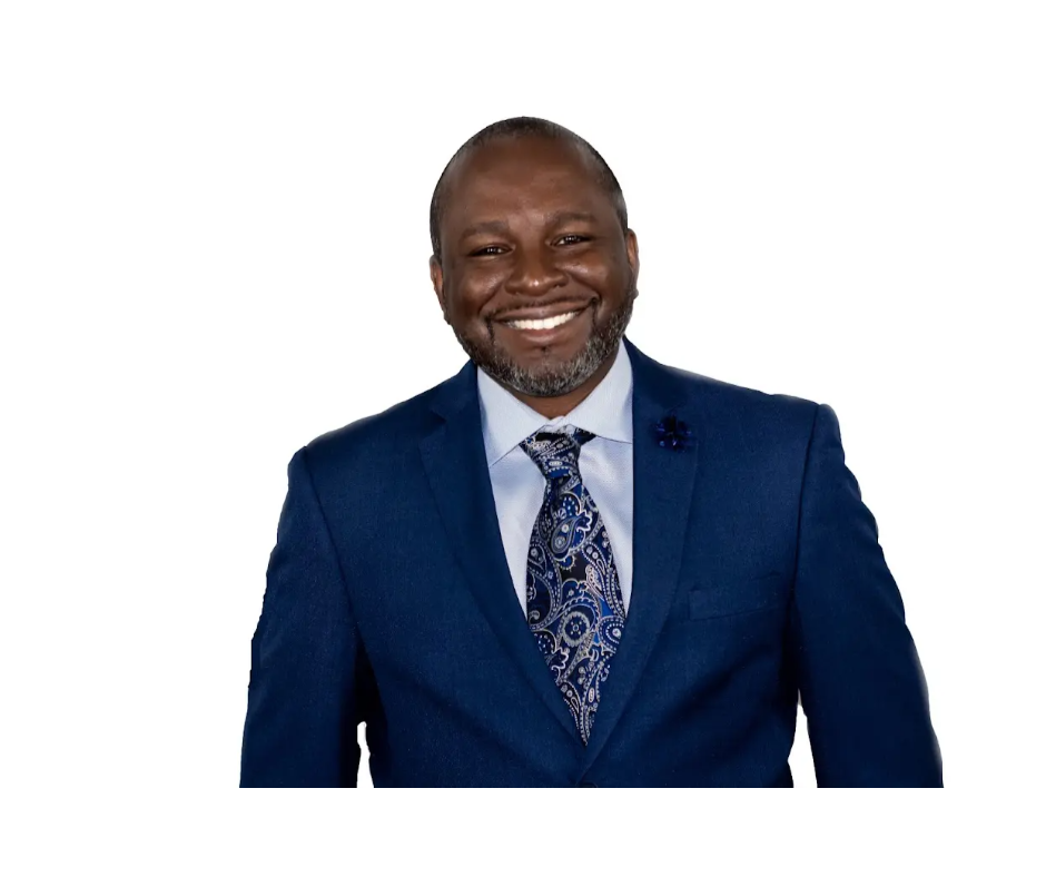 A man in a suit and tie smiling for the camera.